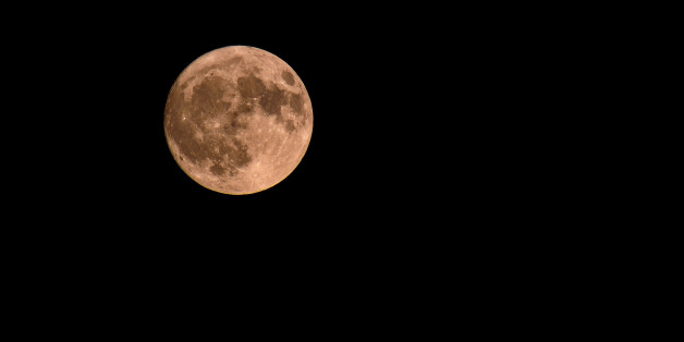 Full moon over dark black sky at night