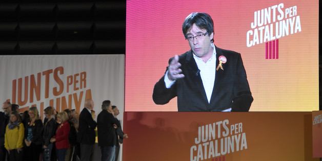 'Junts per Catalonia' (All for Catalonia) grouping cadidate for the upcoming Catalan regional election, Carles Puigdemont, appears on a screen to take part in the campaign opening meeting in Barcelona, on December 4, 2017.Catalans remain deeply split on independence, and several polls suggest pro-secession parties might struggle to win enough seats to form a new regional government after the December 21 regional election. / AFP PHOTO / LLUIS GENE (Photo credit should read LLUIS GENE/AFP/G
