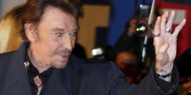 French singer Johnny Hallyday waves as he arrives at the Cannes festival palace to attend the NRJ Music Awards in Cannes January 28, 2012. REUTERS/Eric Gaillard (FRANCE - Tags: ENTERTAINMENT)