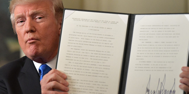 US President Donald Trump holds up a signed memorandum after he delivered a statement on Jerusalem from the Diplomatic Reception Room of the White House in Washington, DC on December 6, 2017. President Donald Trump on Wednesday recognized the disputed city of Jerusalem as Israel's capital -- a historic decision that overturns decades of US policy and risks triggering a fresh spasm of violence in the Middle East.'I have determined that it is time to officially recognize Jerusalem as the capital o