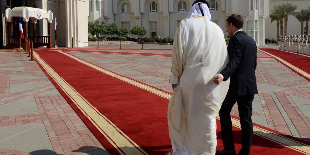 French President Emmanuel Macron (R) walks alongside Qatari Emir Sheikh Tamim bin Hamad al-Thani during a welcome ceremony in Doha on December 7, 2017. / AFP PHOTO / POOL / Ammar ABD RABBO (Photo credit should read AMMAR ABD RABBO/AFP/Getty Images)