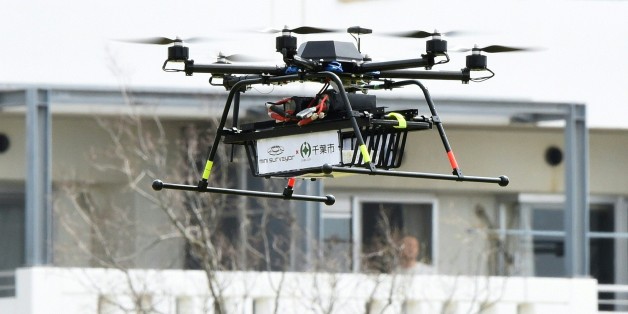 A drone developed by Japan's Autonomous Control Systems Laboratory (ACSL) flies beside a condomimium for a field test in Chiba, suburb of Tokyo, on April 11, 2016. The Japanese government, Chiba City and ACSL jointly carried out a proof experiment for a door-to-door parcel delivery service by the drone equipped with a GPS function. / AFP / TORU YAMANAKA (Photo credit should read TORU YAMANAKA/AFP/Getty Images)