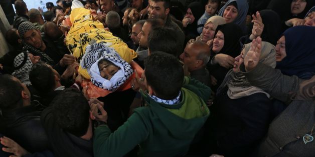 Palestinian mourners carry the body of Mahmoud al-Masri, a 30-year-old Palestinian man who was killed the previous day in clashes with Israeli troops, during his funeral in Khan Younis, in the southern Gaza Strip, on December 9, 2017.Clashes, Palestinian rocket fire and Israeli air strikes killed at least two people and wounded dozens of others on December 8 in violence linked to US President Donald Trump's declaration of Jerusalem as Israel's capital. / AFP PHOTO / MOHAMMED ABED (Photo c