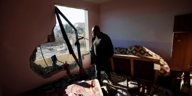 A Palestinian man looks out of his apartment that was damaged in an Israeli airstrike at a nearby militant target in the northern Gaza Strip December 9, 2017. REUTERS/Mohammed Salem