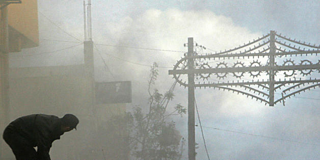 ZERALDA, ALGERIA: An Algerian firefighter on his truck, works on a burning public Bank of Development in the center of Zeralda, in the outer western suburbs of Algiers 06 March 2006. Hundreds of youths attacked government post and bank buildings in protest of the killing of a young man in the police station. A security source said the young man entered the station at three o'clock in the morning with an axe to settle a dispute with a policeman over a love interest, and was shot by one of the po