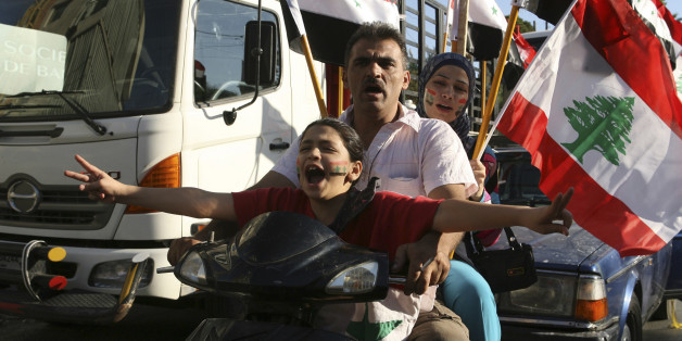 Protesters riding a motorcycle carry flags and gesture during a demonstration against potential U.S. strikes on Syria, near the U.S. embassy in Awkar, north of Beirut, September 7, 2013. U.S. officials ordered non-emergency personnel and their family members out of Lebanon on Friday "due to threats," the U.S. embassy in Beirut said in statement. REUTERS/Hasan Shaaban (LEBANON - Tags: CIVIL UNREST POLITICS)