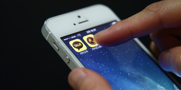 The app icon for KakaoTalk, a messaging app developed by Kakao Corp., left, is displayed on an Apple Inc. iPhone 5 in this arranged photograph taken in Seoul, South Korea, on Monday, Dec. 30, 2013. Kakao is South Korea's biggest mobile messenger operator. Photographer: SeongJoon Cho/Bloomberg via Getty Images