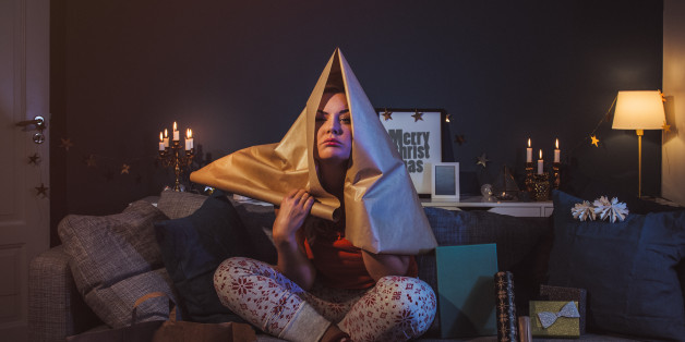 Upset woman at home with christmas gifts