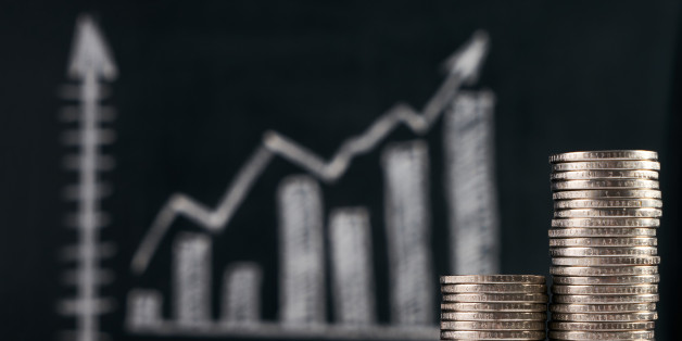 Business and growing finance concept with graph and coins on blackboard.