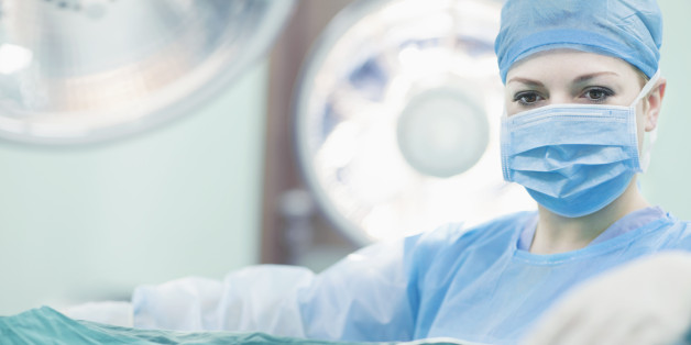 Doctor reaching for surgical tools in hospital operating room