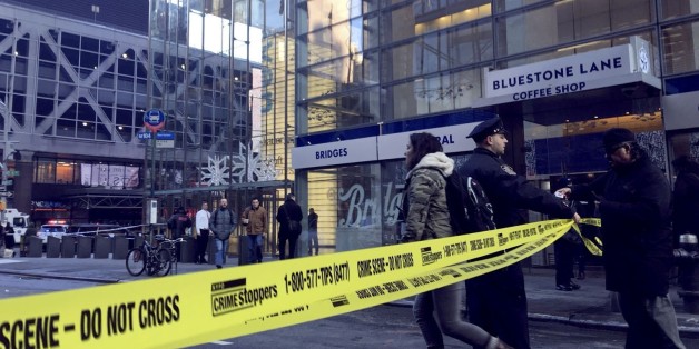 NEW YORK, USA - DECEMBER 11 : A New York Police Department (NYPD) officer allows a girl through 'Do Not Cross' taped street after an explosion occured at the Port Authority Bus Terminal in New York, United States on December 11, 2017. (Photo by Ertugrul Cingil/Anadolu Agency/Getty Images)