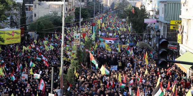 Supporters of Lebanon's Hezbollah Shiite movement wave national, Palestinian and Hezbollah flags during a massive rally in the Lebanese capital Beirut on December 11, 2017 in protest against the US president's controversial recognition of Jerusalem as Israel's capital. / AFP PHOTO / Joseph EID (Photo credit should read JOSEPH EID/AFP/Getty Images)
