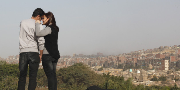 A couple poses for a picture in front of their friends at a public park during Valentines day, in Cairo February 14, 2014 REUTERS/Asmaa Waguih (EGYPT - Tags: SOCIETY)