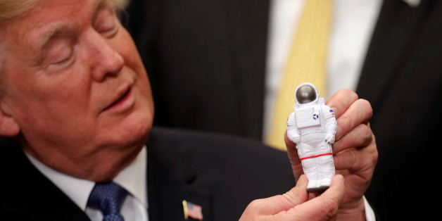 U.S. President Donald Trump holds a space astronaut toy as he participates in a signing ceremony for Space Policy Directive at the White House in Washington D.C., U.S., December 11, 2017. REUTERS/Carlos Barria TPX IMAGES OF THE DAY