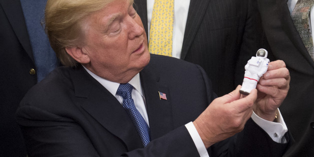 US President Donald Trump holds an Astronaut toy after a signing ceremony for Space Policy Directive 1, with the aim of returning Americans to the Moon, in the Roosevelt Room at the White House in Washington, DC, December 11, 2017. / AFP PHOTO / SAUL LOEB (Photo credit should read SAUL LOEB/AFP/Getty Images)
