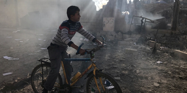 A Palestinian boy rides a bicycle near a militant target that was hit in an Israeli airstrike in the northern Gaza Strip. REUTERS/Mohammed Salem