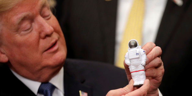 U.S. President Donald Trump holds a space astronaut toy as he participates in a signing ceremony for Space Policy Directive at the White House in Washington D.C., U.S., December 11, 2017. REUTERS/Carlos Barria TPX IMAGES OF THE DAY