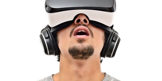 Young man wearing vr headset and handphones. Isolated on white. Wearable technology concept.