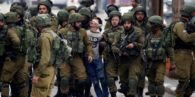HEBRON, WEST BANK - DECEMBER 7 : Israeli forces detain Palestinian Fevzi El-Junidi, 14-year-old, following clashes after protests against a decision by US President Donald Trump to recognize Jerusalem as the capital of Israel, in the West Bank city Hebron, 07 December 2017. (Photo by Wisam Hashlamoun/Anadolu Agency/Getty Images)