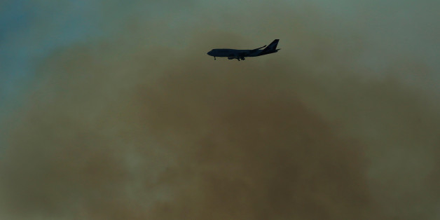 A Qantas Boeing 747 prepares to land at Sydney International Airport through smoke caused by a bushfire burning on the Kurnell Peninsula of Sydney, Australia, September 4, 2017. REUTERS/Jason Reed