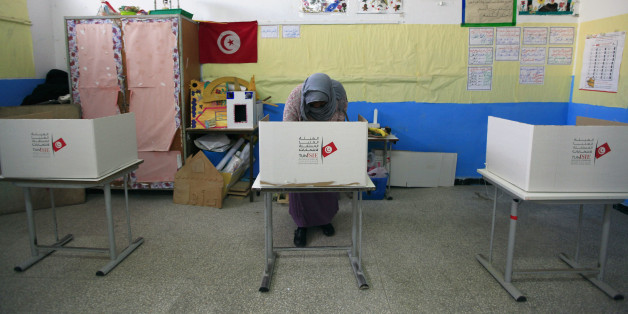 A Tunisian woman casts her ballot in the capital Tunis December 21, 2014. Tunisians began voting on Sunday in a presidential run-off election that completes the country's last steps to full democracy nearly fours years after an uprising that toppled autocrat Zine El-Abidine Ben Ali. REUTERS/Anis Mili (TUNISIA - Tags: ELECTIONS POLITICS)