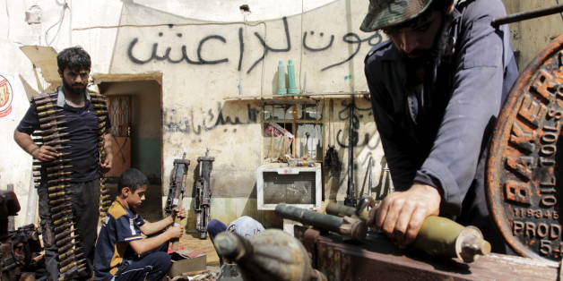 Iraqi volunteers fix the weapons of the Hashid Shaabi militia, at a shop on the outskirts of Basra June 16, 2015. The Arabic writing on the wall reads, "Death to DAESH (Arabic name for the Islamic State, or ISIL)". REUTERS/Stringer
