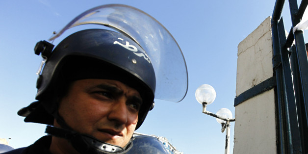 Riot police stand outside the gate during a strike by medical staff at University Hospital Mustapha Bacha in Algiers February 3, 2010. The medical staff staged the protest to demand for better terms of employment. Their leaders said they planned to march towards the presidential administration, but police, acting on the basis of a law banning protest marches in Algeria, prevented them from leaving the grounds of the hospital. REUTERS/Zohra Bensemra (ALGERIA - Tags: POLITICS HEALTH EMPLOYMENT BUS