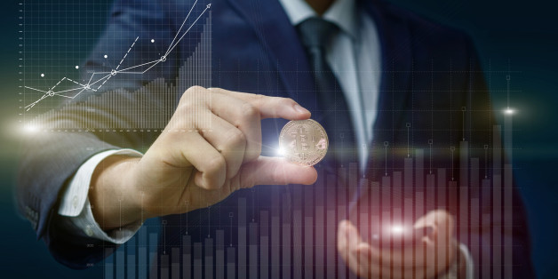 Bitcoin in the hands of a businessman on the background of the chart profit growth.
