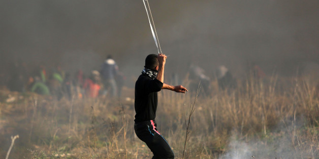 Palestinian protesters hurl stones towards Israeli troops during clashes following a protest against US President Donald Trump's decision to recognize Jerusalem as the capital of Israel, near the Gaza-Israel borders, East of Gaza City, 15 December 2017. (Photo by Majdi Fathi/NurPhoto via Getty Images)
