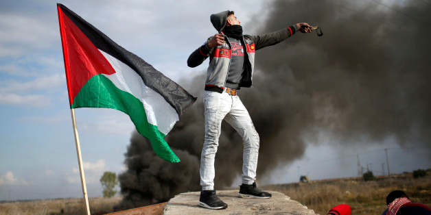 Un manifestant palestinien lance une pierre contre les troupes israéliennes pendant une manifestation contre la décision de Donald Trump de reconnaître Jérusalem comme la capitale d'Israël, à l'est de Gaza, 15 décembre 2017.