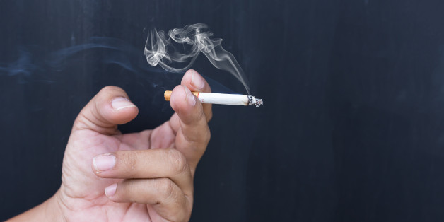 Close up cigarette or tobacco with smoke in hand and copy space'n
