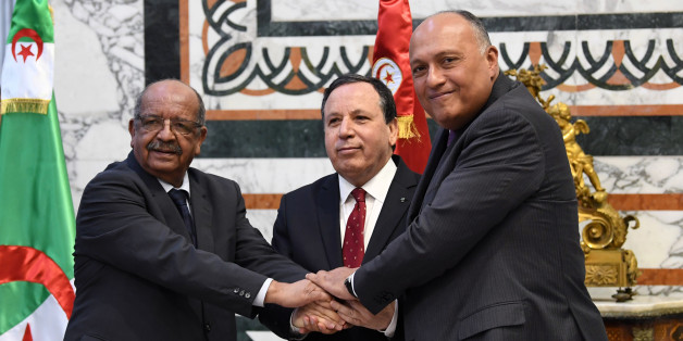Tunisian Foreign Minister Khemaies Jhinaoui (C) holds hands with his Algerian counterpart Abdelkader Messahel (L) and Egyptian counterpart Sameh Shoukry (R) as they pose for a picture before a meeting to discuss efforts to resolve the Libyan conflict in the capital Tunis on December 17, 2017. / AFP PHOTO / FETHI BELAID (Photo credit should read FETHI BELAID/AFP/Getty Images)