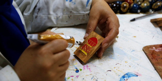 A Tunisian woman works on wooden objects at her workshop in Tunis, Tunisia July 13, 2017. REUTERS/Zoubeir Souissi