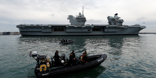 Police officers stand guard in a rigid inflatable boat (RIB) as the Royal Navy's new aircraft carrier HMS Queen Elizabeth arrives in Portsmouth, Britain August 16, 2017. REUTERS/Peter Nicholls