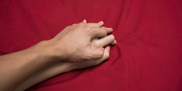 Young couple making love in bed focus on hand