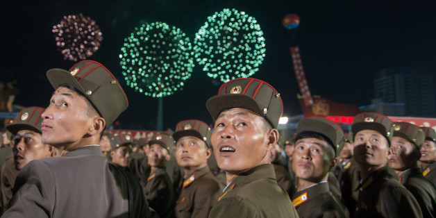 TOPSHOT - In a photo taken on September 6, 2017, Korean People's Army (KPA) soldiers cheer while watching fireworks during a mass celebration in Pyongyang for scientists involved in carrying out North Korea's largest nuclear blast to date.Citizens of the capital lined the streets September 6 to wave pink and purple pom-poms and cheer a convoy of buses carrying the specialists into the city, and toss confetti over them as they walked into Kim Il-Sung Square. / AFP PHOTO / Kim Won-Jin (Phot