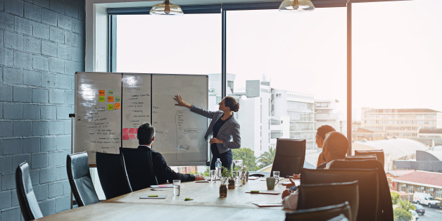 Shot of an executive giving a whiteboard presentation to a group of colleagues in a boardroom