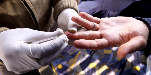 A nurse takes blood from a man who got a free HIV test on a bus in Tehran December 16, 2015. A team of medical experts travelled on a bus to different neighborhoods of Tehran, stationing there for some days to provide education and medical services on the HIV/AIDS disease. They also performed HIV tests on residents. REUTERS/Raheb Homavandi/TIMA ATTENTION EDITORS - THIS IMAGE WAS PROVIDED BY A THIRD PARTY. FOR EDITORIAL USE ONLY.