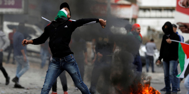A Palestinian demonstrator hurls a stones towards Israeli troops during clashes at a protest as Palestinians call for a "Day of Rage" in response to U.S. President Donald Trump's recognition of Jerusalem as Israel's capital, near the West Bank city of Nablus December 22, 2017. REUTERS/Mohamad Torokman