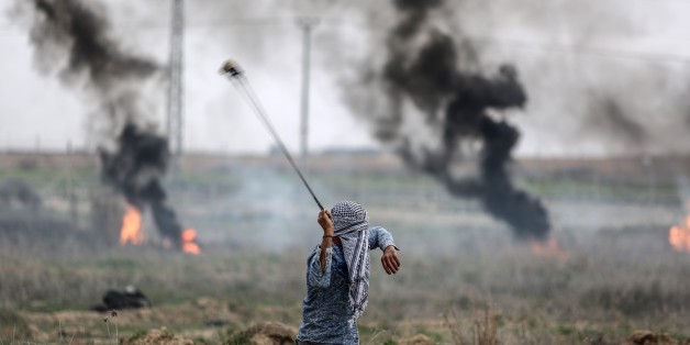 GAZA CITY, GAZA - DECEMBER 22 : A Palestinian protester uses slingshot to throw at Israeli security forces during a demonstration against U.S. President Donald Trump's recognition of Jerusalem as Israel's capital, at Israeli border in Shuja'iyya neighborhood of Gaza City, Gaza on December 22, 2017. (Photo by Ali Jadallah/Anadolu Agency/Getty Images)