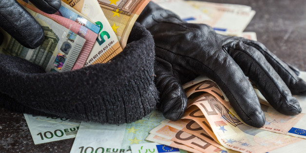 Quick loot in the store. Thief' s hands in black leather gloves stealing a money and putting it in the his hat. Many money.