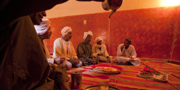 Dates and sweet tea being served to visitors in Bamhar village, some 40 km south of Adrar. The town is supplied with irrigation water by an ancient and well-maintained network of 'foggara' or subterranean aqueducts. The young people are not interested in the hard work of maintaining the foggara, so the work rests with this group of old men seen here.