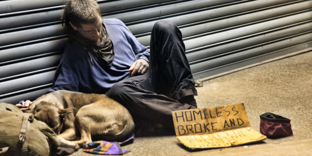 New York, USA - May 16, 2013: homeless man sleeping with dog on sidewalk on 8th Ave and 42th Street, Manhattan, NY.