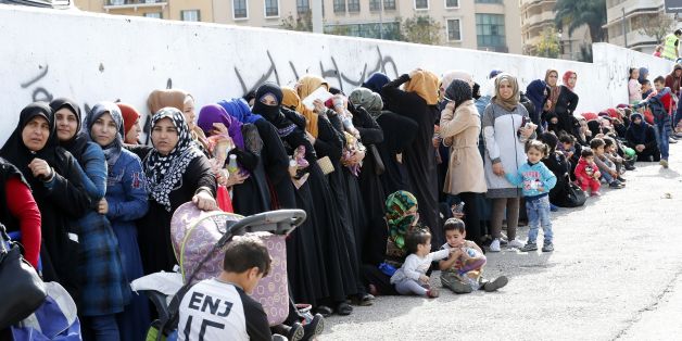 Syrian refugees queue to receive aid consisting of winter clothing, blankets, heaters and other necessities, in the capital Beirut's Martyrs Square on November 26, 2017, as part of the 'Dafa' campaign aimed at helping Syrian refugees and Lebanese families in need. / AFP PHOTO / ANWAR AMRO (Photo credit should read ANWAR AMRO/AFP/Getty Images)