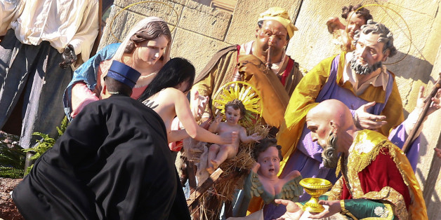 Vatican gendarmes attempt to block a topless activist of women's rights group Femen, who tries to reach the Nativity scene in Saint Peter's square at the Vatican December 25, 2017. REUTERS/Alessandro Bianchi TEMPLATE OUT
