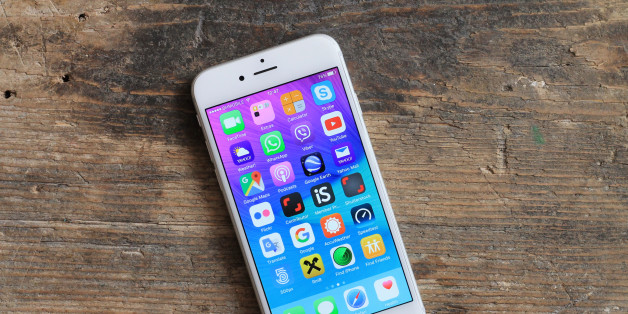 Sarajevo , Bosnia and Herzegovina - January 02 , 2016 : New gray iPhone 6 with colorful screen on the wooden table. iPhone 6 was created and developed by the Apple inc.