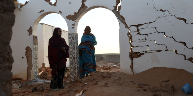 Sahrawi refugee women (L) stand at their house which was destroyed during heavy rain last year at the Boujdour refugee camp, west of the Algerian city of Tindouf in the disputed territory of Western Sahara, on March 3, 2016. / AFP / Farouk Batiche (Photo credit should read FAROUK BATICHE/AFP/Getty Images)
