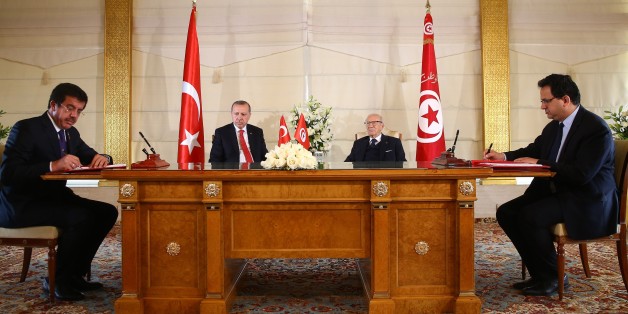 TUNIS, TUNISIA - DECEMBER 27: Turkish Economy Minister Nihat Zeybekci (L) and his Tunisian counterpart sign a bilateral agreement as they are flanked by President of Turkey Recep Tayyip Erdogan (2nd L) and Tunisian President Beji Caid Essebsi (2nd R) in Tunis, Tunisia on December 27, 2017. (Photo by Kayhan Ozer/Anadolu Agency/Getty Images)