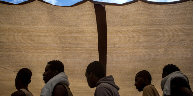 REGGIO CALABRIA, ITALY - JUNE 12: Refugees and migrants are seen waiting to disembark the Migrant Offshore Aid Station (MOAS) Phoenix vessel after arriving in port on June 12, 2017 in Reggio Calabria, Italy. An estimated 230,000 refugees and migrants will arrive in Italy this year as numbers of refugees and migrants attempting the dangerous central mediterranean crossing from Libya to Italy continues to rise since the same time last year. So far this year more than 58,000 people have arrived in Italy and 1,569 people have died attempting the crossing. Libya continues to be the primary departure point for refugees and migrants taking the central mediterranean route to Sicily. In an attempt to slow the flow of migrants, Italy recently signed a deal with Libya, Chad and Niger outlining a plan to increase border controls and add new reception centers in the African nations, which are key transit points for migrants heading to Italy. MOAS is a Malta based NGO dedicated to providing professional search-and-rescue assistance to refugees and migrants in distress at sea. Since the start of the year MOAS have rescued and assisted more than 4000 people and are currently patrolling and running rescue operations in international waters off the coast of Libya. (Photo by Chris McGrath/Getty Images)