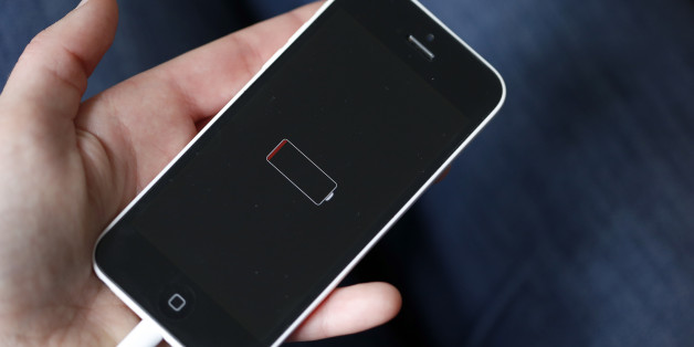 PARIS, FRANCE - DECEMBER 23: In this photo illustration a woman holds an Apple mobile phone iPhone 5 on the screen of which we can see the battery charge indicator on December 23, 2017 in Paris, France. Apple has admitted that it was clamping the processors of old iPhone at certain stages of their life cycles, to deliberately slow down the performance of batteries of older models of iPhone. (Photo by Chesnot/Getty Images)
